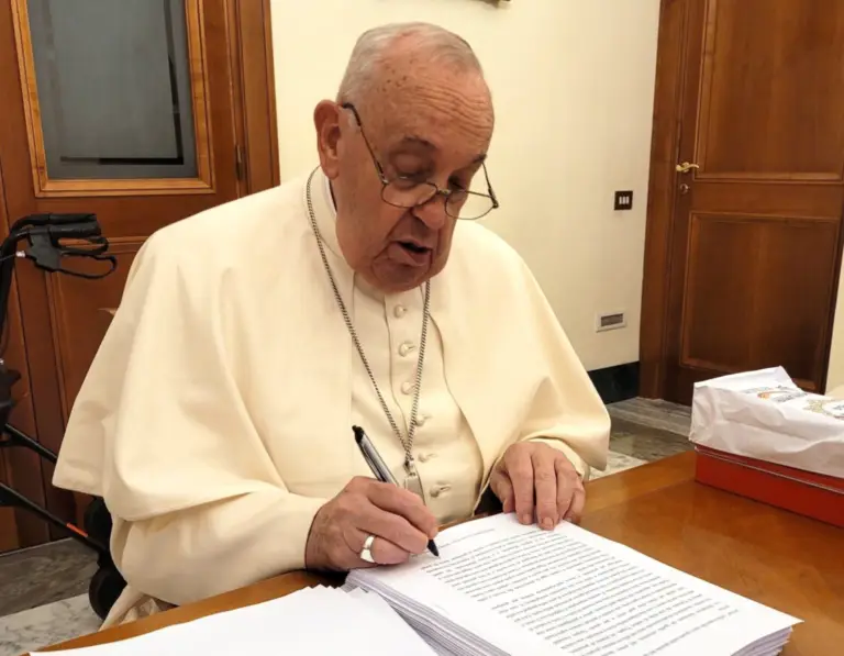 Papa Francisco escribiendo a mano sobre una agenda.